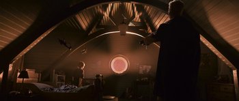 Movie still from “Knowing” (2009), directed by Alex Proyas – A man standing in front of a window in a room; Wide shot, Low angle