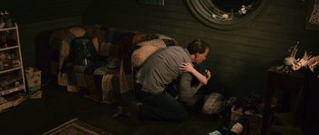 Movie still from “Knowing” (2009), directed by Alex Proyas – A man kneeling on the ground while holding a camera; Medium shot, High angle
