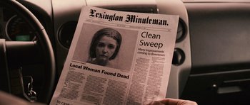 Movie still from “Knowing” (2009), directed by Alex Proyas – A person holding up a newspaper in front of a window; Extreme Close Up shot, Over the shoulder angle