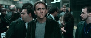 Movie still from “Knowing” (2009), directed by Alex Proyas – A man in a gray shirt and a black jacket; Close Up shot, Low angle