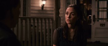 Movie still from “Knowing” (2009), directed by Alex Proyas – A woman sitting on a chair in front of a porch; Close Up shot, Over the shoulder angle