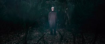 Movie still from “Knowing” (2009), directed by Alex Proyas – A man standing in the middle of a forest; Wide shot, High angle