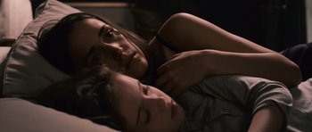 Movie still from “Knowing” (2009), directed by Alex Proyas – A woman laying in bed next to a sleeping child; Close Up shot, Overhead angle