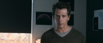 Movie still from “Knowing” (2009), directed by Alex Proyas – A person wearing a brown and black shirt; Close Up shot, Over the shoulder angle