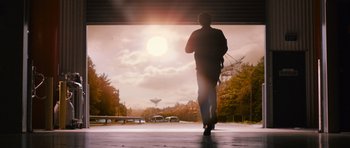 Movie still from “Knowing” (2009), directed by Alex Proyas – A man is walking on the sidewalk in the sun; Extreme Wide shot, Low angle