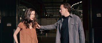 Movie still from “Knowing” (2009), directed by Alex Proyas – A man and a woman in an industrial setting; Medium shot, Over the shoulder angle