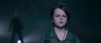 Movie still from “Knowing” (2009), directed by Alex Proyas – A young boy is looking into the camera; Close Up shot, Low angle