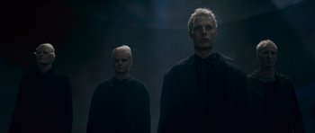 Movie still from “Knowing” (2009), directed by Alex Proyas – Two men standing in the dark wearing black shirts; Medium shot, Low angle