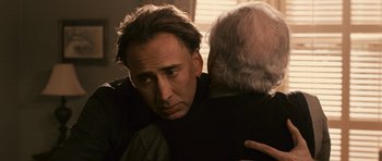 Movie still from “Knowing” (2009), directed by Alex Proyas – A person with his arms around another person; Close Up shot, Over the shoulder angle
