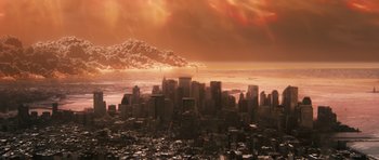 Movie still from “Knowing” (2009), directed by Alex Proyas – An aerial view of a city with a mountain in the background; Extreme Wide shot, High angle