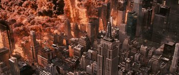 Movie still from “Knowing” (2009), directed by Alex Proyas – An aerial view of a city with a lot of smoke and fire coming out of it; Extreme Wide shot, High angle