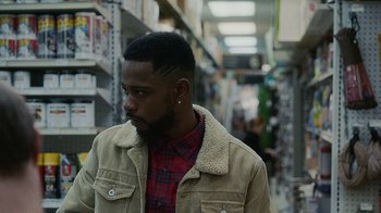 Movie still from “Atlanta” (2016), created by Donald Glover – A man with a beard is standing in a store; Close Up shot, Over the shoulder angle