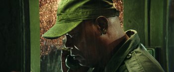 Movie still from “Kong: Skull Island” (2017), directed by Jordan Vogt-Roberts – A person talking on a cell phone; Close Up shot, Low angle