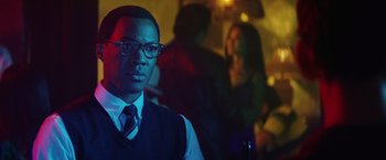 Movie still from “Kong: Skull Island” (2017), directed by Jordan Vogt-Roberts – A man in a vest and tie holding a bottle of beer; Close Up shot, Over the shoulder angle