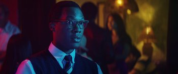 Movie still from “Kong: Skull Island” (2017), directed by Jordan Vogt-Roberts – A man wearing glasses and a vest and a tie; Close Up shot, Over the shoulder angle