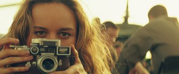 Movie still from “Kong: Skull Island” (2017), directed by Jordan Vogt-Roberts – A woman taking a picture with a camera; Close Up shot, Low angle