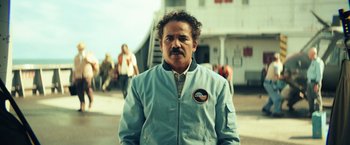 Movie still from “Kong: Skull Island” (2017), directed by Jordan Vogt-Roberts – A man in a blue jacket standing in front of an airplane; Medium shot, Low angle