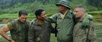 Movie still from “Kong: Skull Island” (2017), directed by Jordan Vogt-Roberts – A man in a hat is touching another man in a uniform; Medium shot, Over the shoulder angle