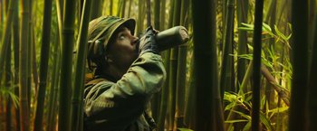 Movie still from “Kong: Skull Island” (2017), directed by Jordan Vogt-Roberts – A man in a hat and gloves is drinking from a bottle; Close Up shot, Low angle