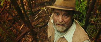 Movie still from “Kong: Skull Island” (2017), directed by Jordan Vogt-Roberts – An older man wearing a hat in the woods; Close Up shot, Low angle