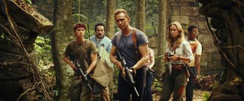 Movie still from “Kong: Skull Island” (2017), directed by Jordan Vogt-Roberts – A group of people standing in the woods holding guns; Medium shot, Low angle