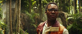 Movie still from “Kong: Skull Island” (2017), directed by Jordan Vogt-Roberts – A man with glasses standing next to a forest; Close Up shot, Low angle