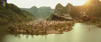 Movie still from “Kong: Skull Island” (2017), directed by Jordan Vogt-Roberts – An aerial view of a village on a river; Extreme Wide shot, High angle