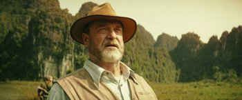 Movie still from “Kong: Skull Island” (2017), directed by Jordan Vogt-Roberts – An older man wearing a brown hat and a white shirt; Close Up shot, Low angle