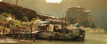Movie still from “Kong: Skull Island” (2017), directed by Jordan Vogt-Roberts – A man standing on top of a boat in the water; Extreme Wide shot, High angle