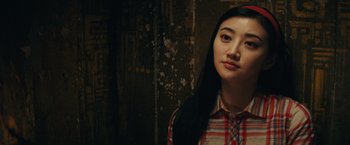 Movie still from “Kong: Skull Island” (2017), directed by Jordan Vogt-Roberts – A woman with long black hair wearing a red and white plaid shirt; Close Up shot, Over the shoulder angle