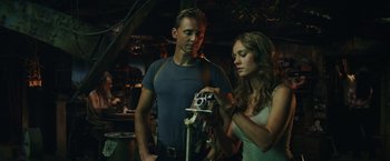 Movie still from “Kong: Skull Island” (2017), directed by Jordan Vogt-Roberts – A man and a woman looking at a camera; Medium shot, Over the shoulder angle