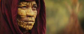 Movie still from “Kong: Skull Island” (2017), directed by Jordan Vogt-Roberts – A man with a face paint and a red hood; Close Up shot, Low angle