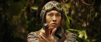 Movie still from “Kong: Skull Island” (2017), directed by Jordan Vogt-Roberts – A man wearing a hat and goggles holding a gun; Close Up shot, Low angle