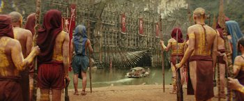 Movie still from “Kong: Skull Island” (2017), directed by Jordan Vogt-Roberts – Two people standing in front of a boat on a body of water; Extreme Wide shot, Low angle