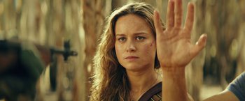 Movie still from “Kong: Skull Island” (2017), directed by Jordan Vogt-Roberts – A beautiful woman with long hair holding up her hand in the air; Close Up shot, Over the shoulder angle