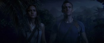 Movie still from “Kong: Skull Island” (2017), directed by Jordan Vogt-Roberts – A man and a woman standing next to each other in the dark; Medium shot, Low angle