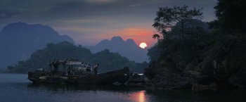 Movie still from “Kong: Skull Island” (2017), directed by Jordan Vogt-Roberts – A man standing on a boat in the middle of a river; Extreme Wide shot, Low angle