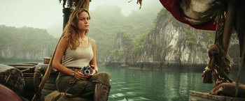 Movie still from “Kong: Skull Island” (2017), directed by Jordan Vogt-Roberts – A woman sitting on a boat in the middle of a river; Medium shot, Low angle