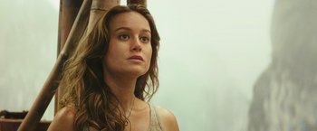 Movie still from “Kong: Skull Island” (2017), directed by Jordan Vogt-Roberts – A beautiful young woman with long brown hair and blue eyes; Close Up shot, Low angle