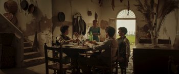 Movie still from “Lamborghini: The Man Behind the Legend” (2022), directed by Bobby Moresco – A group of people sitting at a table with wine glasses; Wide shot, Low angle