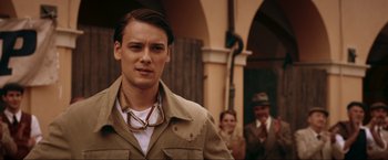 Movie still from “Lamborghini: The Man Behind the Legend” (2022), directed by Bobby Moresco – A man in a tan jacket and a white t - shirt; Close Up shot, Over the shoulder angle