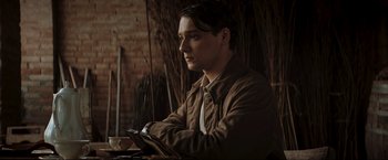 Movie still from “Lamborghini: The Man Behind the Legend” (2022), directed by Bobby Moresco – A man sitting at a table with a cup of coffee; Close Up shot, Low angle