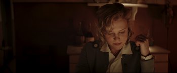 Movie still from “Lamborghini: The Man Behind the Legend” (2022), directed by Bobby Moresco – A woman with blonde curly hair wearing a military uniform; Close Up shot, Low angle