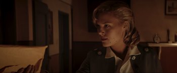 Movie still from “Lamborghini: The Man Behind the Legend” (2022), directed by Bobby Moresco – A young woman with blonde hair wearing a military jacket; Close Up shot, Low angle