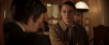 Movie still from “Lamborghini: The Man Behind the Legend” (2022), directed by Bobby Moresco – A man in a brown jacket looking at another man in a brown jacket; Close Up shot, Over the shoulder angle