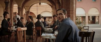 Movie still from “Lamborghini: The Man Behind the Legend” (2022), directed by Bobby Moresco – A group of people sitting around a table; Medium shot, Over the shoulder angle
