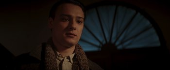 Movie still from “Lamborghini: The Man Behind the Legend” (2022), directed by Bobby Moresco – A young man wearing a sweater and a scarf; Close Up shot, Low angle