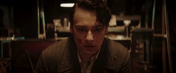 Movie still from “Lamborghini: The Man Behind the Legend” (2022), directed by Bobby Moresco – A young man with blood on his face; Close Up shot, High angle