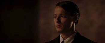 Movie still from “Lamborghini: The Man Behind the Legend” (2022), directed by Bobby Moresco – A man wearing a suit and tie looking to his left; Close Up shot, Low angle