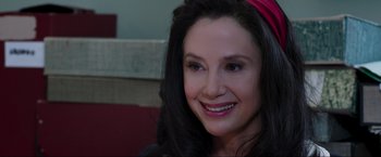 Movie still from “Lamborghini: The Man Behind the Legend” (2022), directed by Bobby Moresco – A person wearing a headband smiling; Close Up shot, Over the shoulder angle